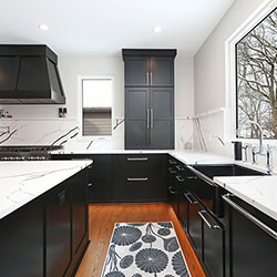 A kitchen interior featuring black cabinets along two walls and a center island