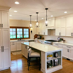 A kitchen interior with white cabinets and a center island