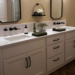 A modern bathroom counter with side-by-side sinks and mirrors