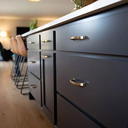 A close-up view of sllding drawers on the side of a kitchen island